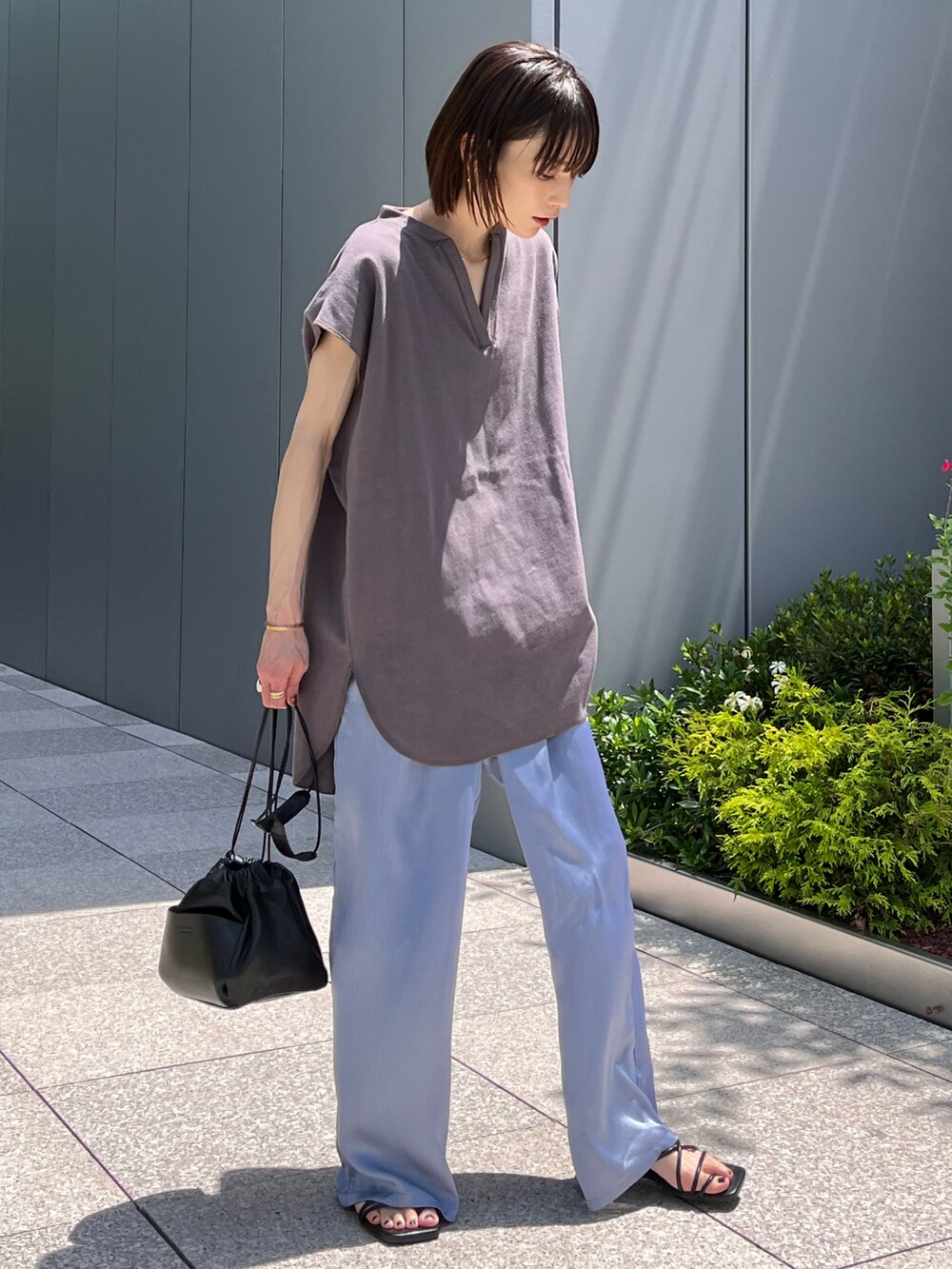 ブルー系のその他パンツ、グレー系のTシャツ/カットソー、ホワイト系のショルダーバッグを着用したレディースの夏コーディネートの2枚目の写真