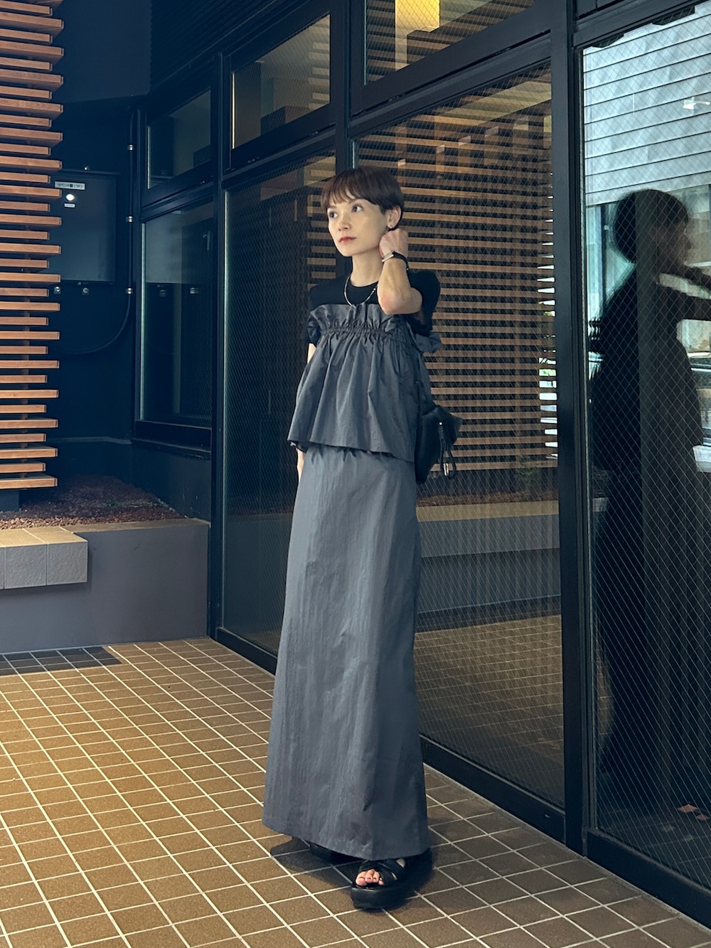 グレー系のスカートを着用したレディースの夏コーディネートの3枚目の写真