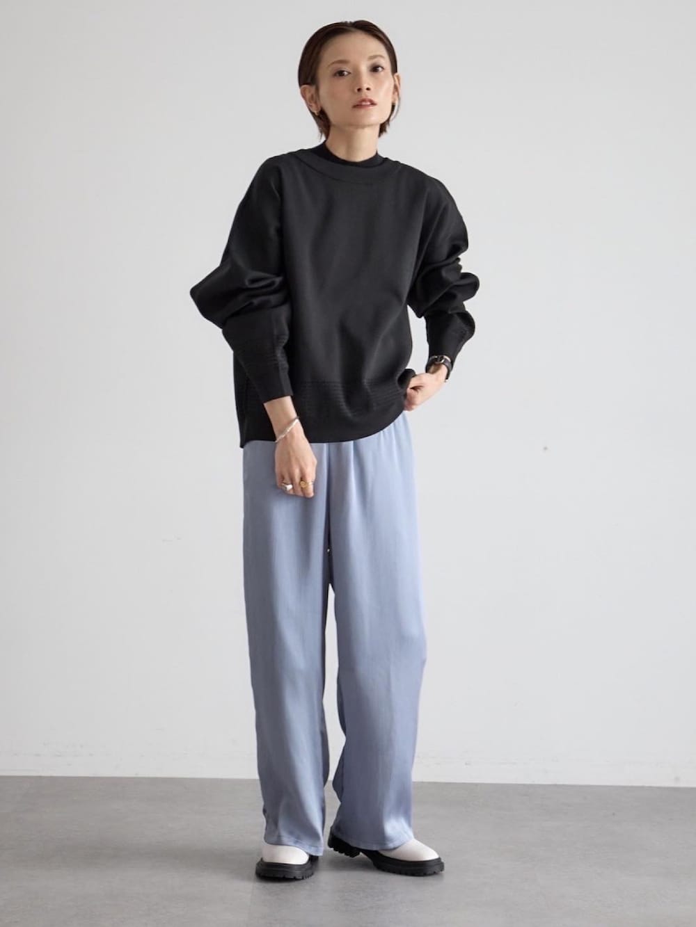ブルー系のその他パンツ、ブラック系のニット/セーター、ホワイト系のブーツを着用したレディースの秋コーディネートの2枚目の写真