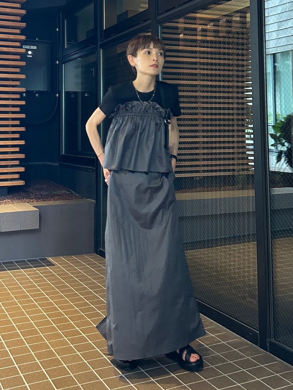 グレー系のスカートを着用したレディースの夏コーディネートの2枚目の写真