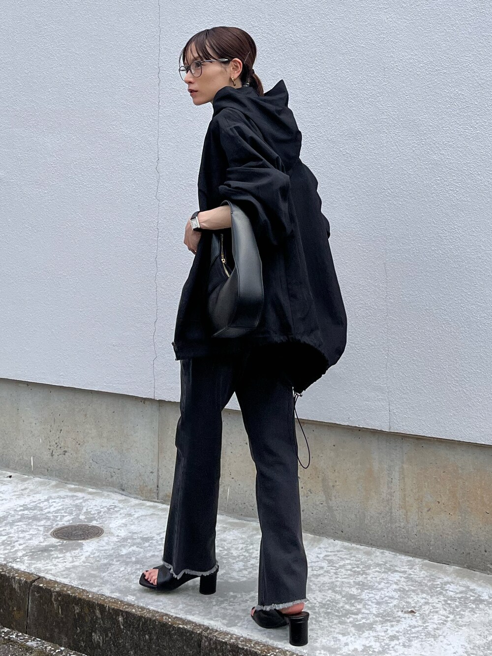 ブラック系のデニムパンツ、ブラック系のブルゾン、ブラック系のショルダーバッグを着用したレディースの夏コーディネートの3枚目の写真