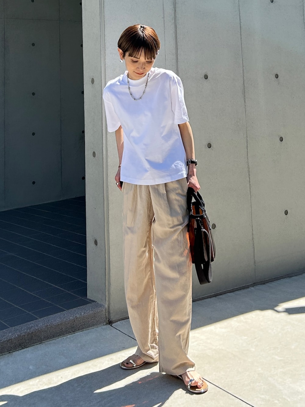 ブラウン系のショルダーバッグ、シルバー系のサンダルを着用したレディースの春コーディネートの2枚目の写真