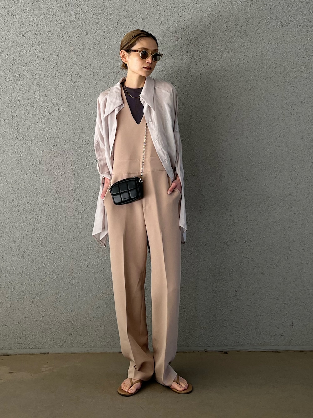 ベージュ系のビーチサンダル、ベージュ系のサロペット/オーバーオール、ブラック系のショルダーバッグを着用したレディースの春コーディネートの3枚目の写真