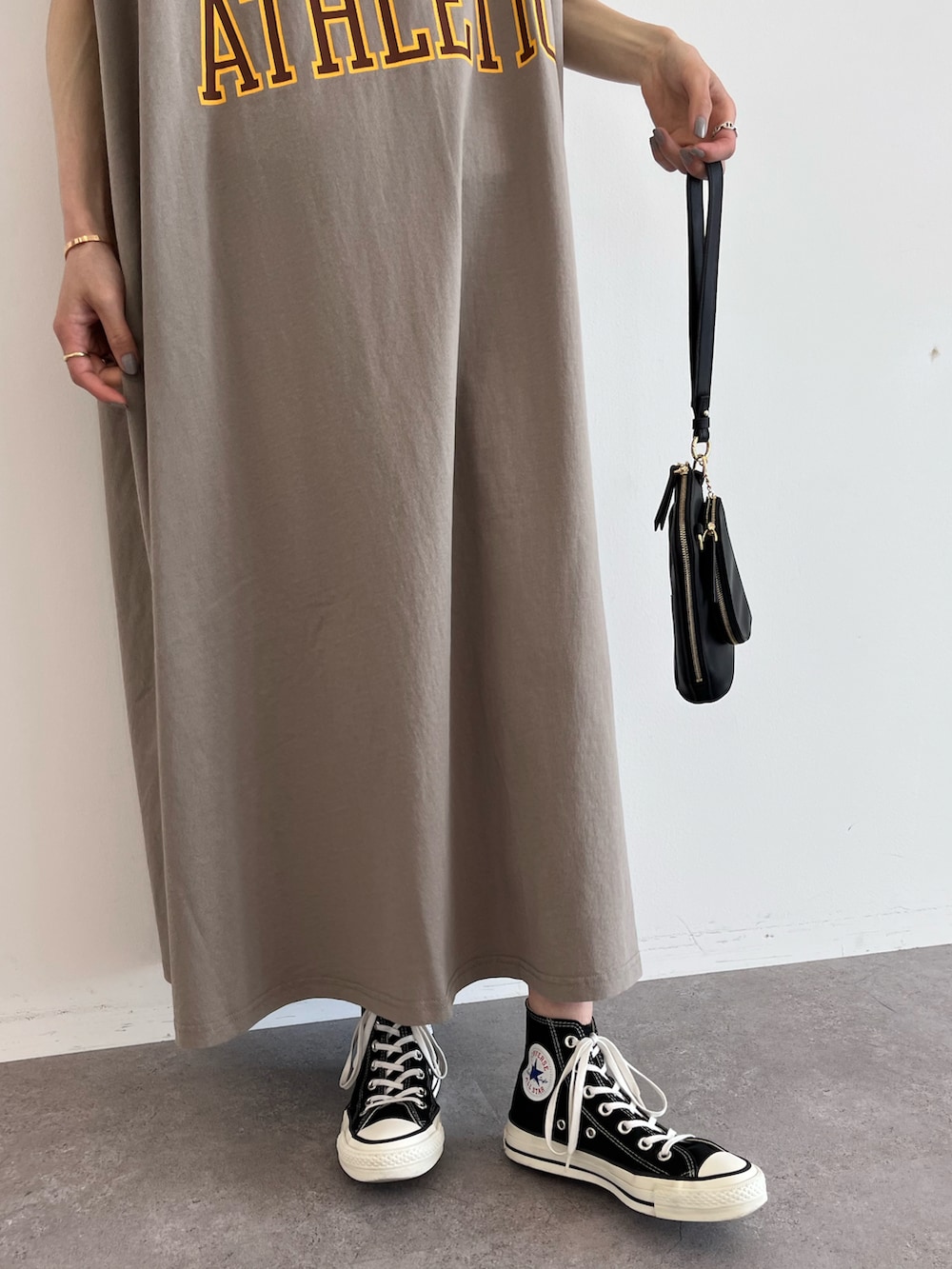 ベージュ系のワンピース、ブラック系のスニーカー、ブラック系のショルダーバッグを着用したレディースの夏コーディネートの3枚目の写真