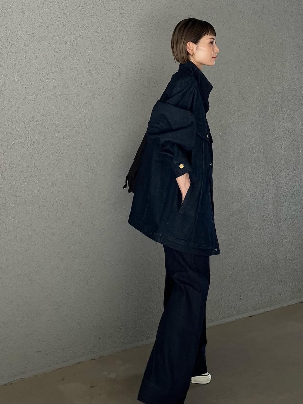 ブルー系のデニムジャケット、ブルー系のデニムパンツ、ブラウン系のショルダーバッグを着用したレディースの夏コーディネートの4枚目の写真