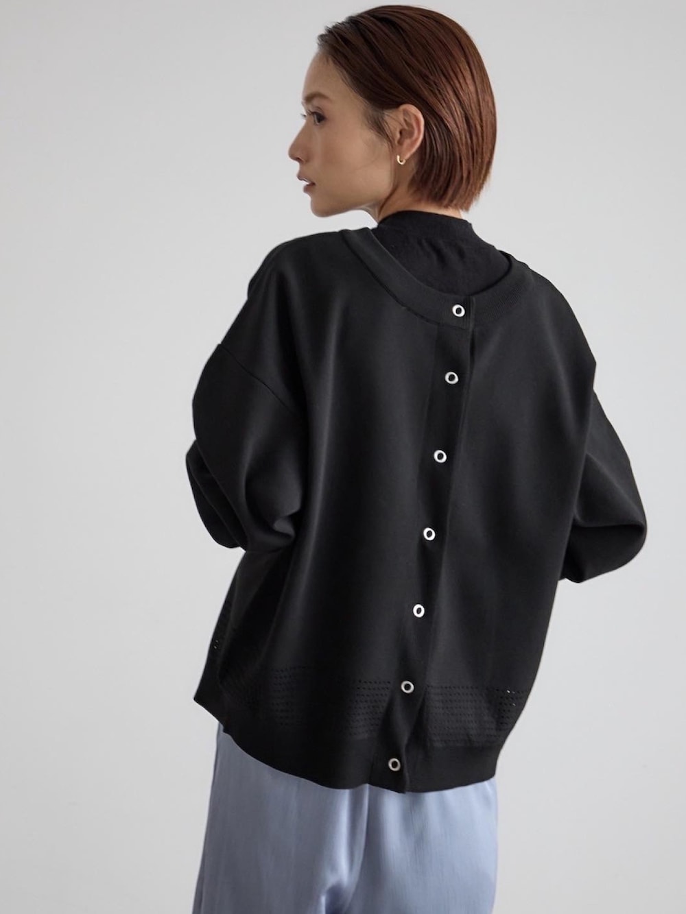 ブルー系のその他パンツ、ブラック系のニット/セーター、ホワイト系のブーツを着用したレディースの秋コーディネートの4枚目の写真