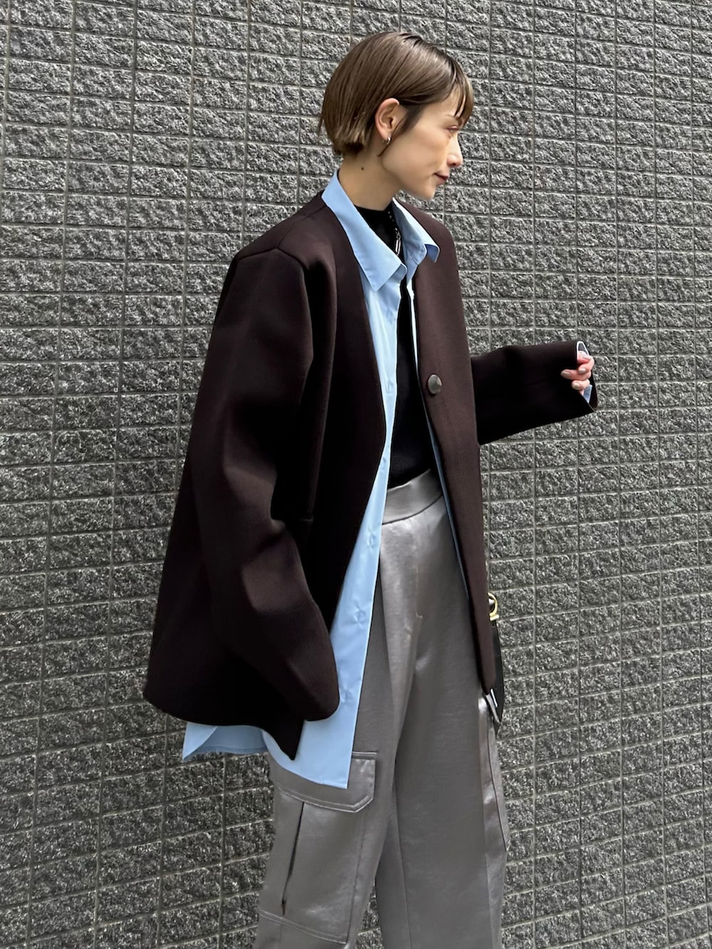 ブラウン系のその他アウター、ブラック系のショルダーバッグ、グレー系のスニーカーを着用したレディースの冬コーディネートの3枚目の写真