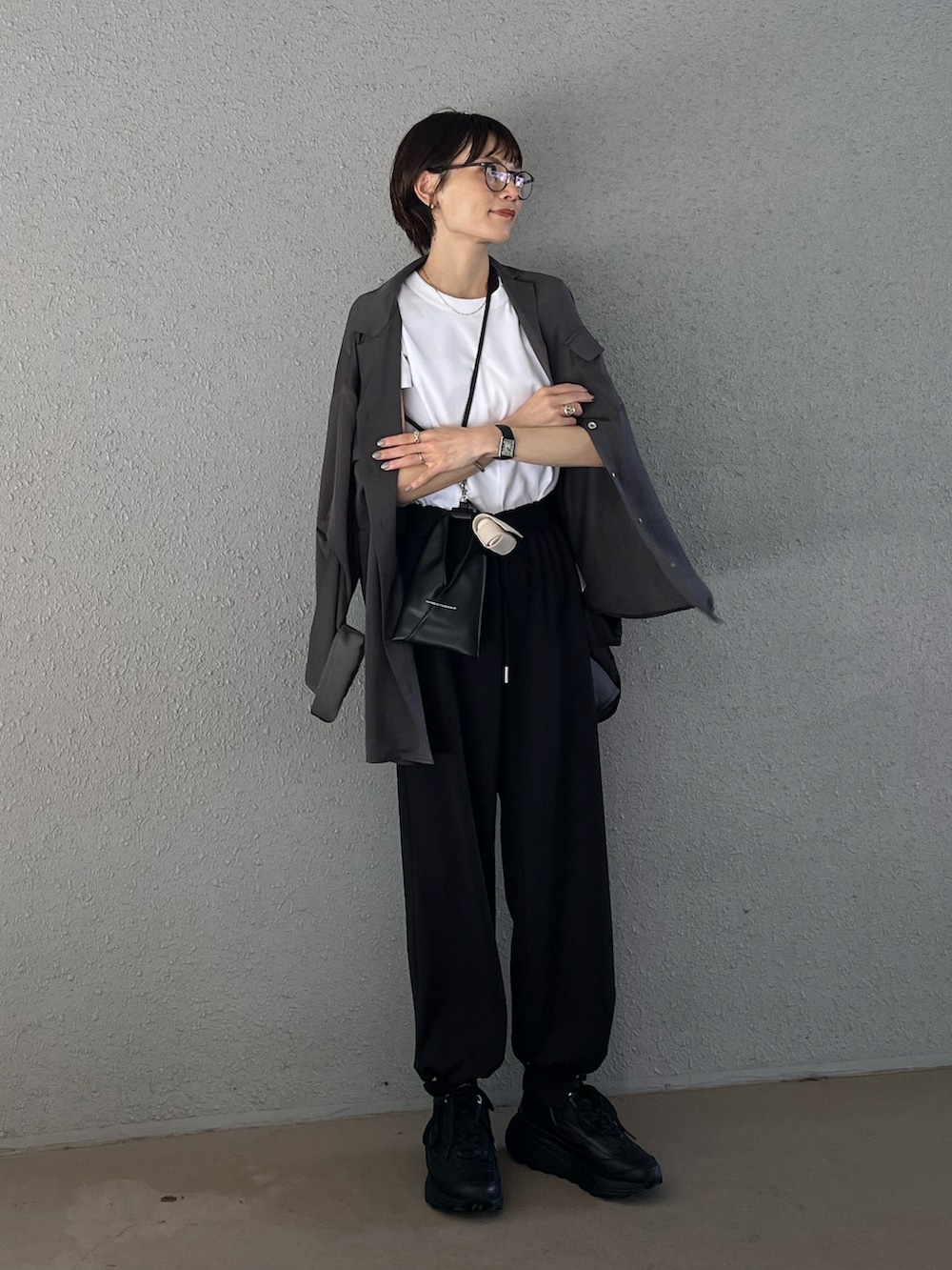 グレー系のシャツ/ブラウス、ブラック系のスニーカー、ホワイト系のTシャツ/カットソーを着用したレディースの夏コーディネートの4枚目の写真