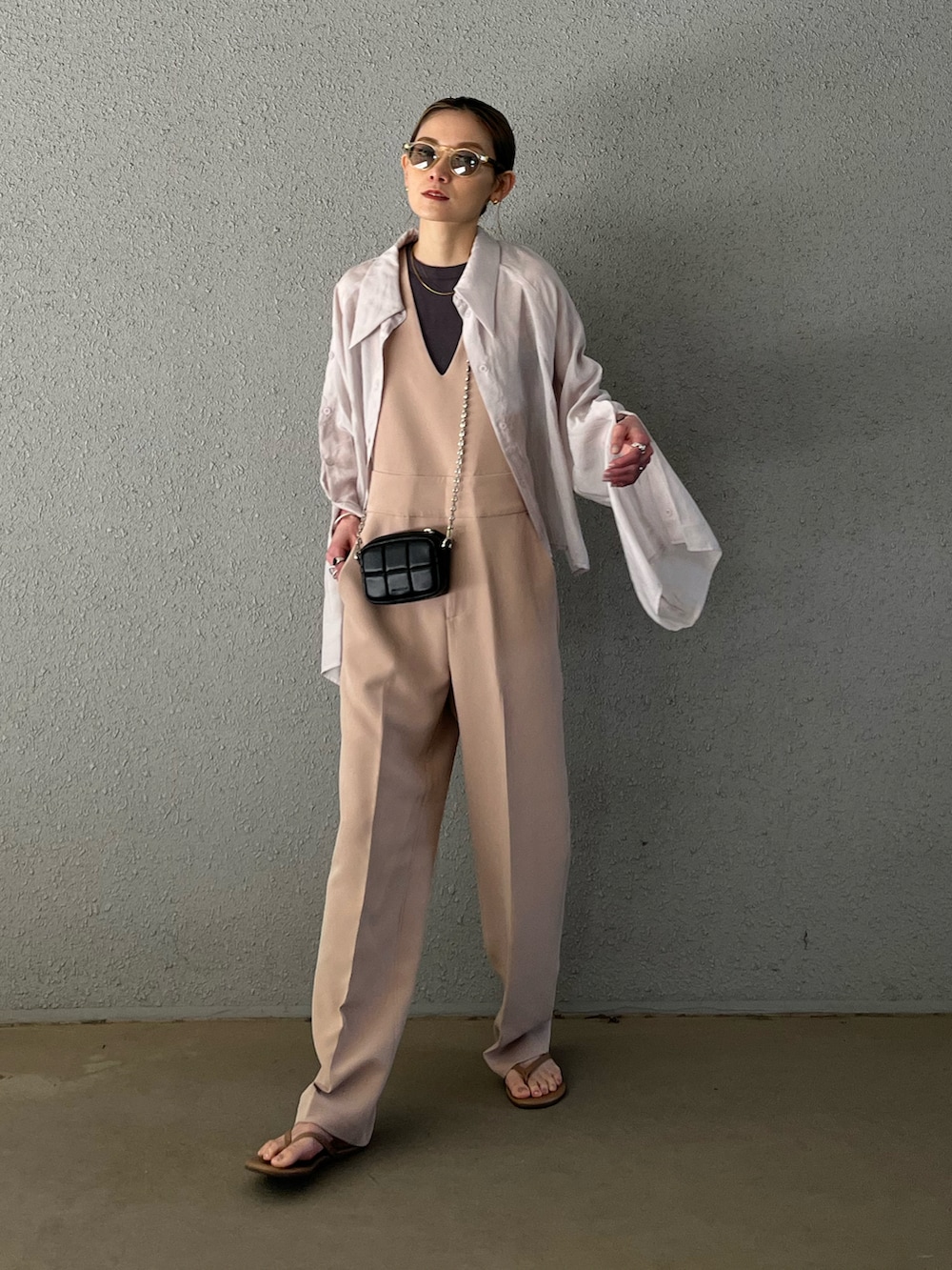 ベージュ系のビーチサンダル、ベージュ系のサロペット/オーバーオール、ブラック系のショルダーバッグを着用したレディースの春コーディネートの5枚目の写真