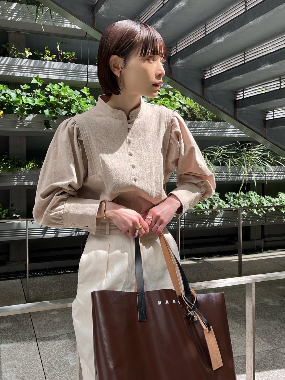 ホワイト系のその他パンツ、ベージュ系のシャツ/ブラウス、ブラウン系のパンプスを着用したレディースの春コーディネートの2枚目の写真