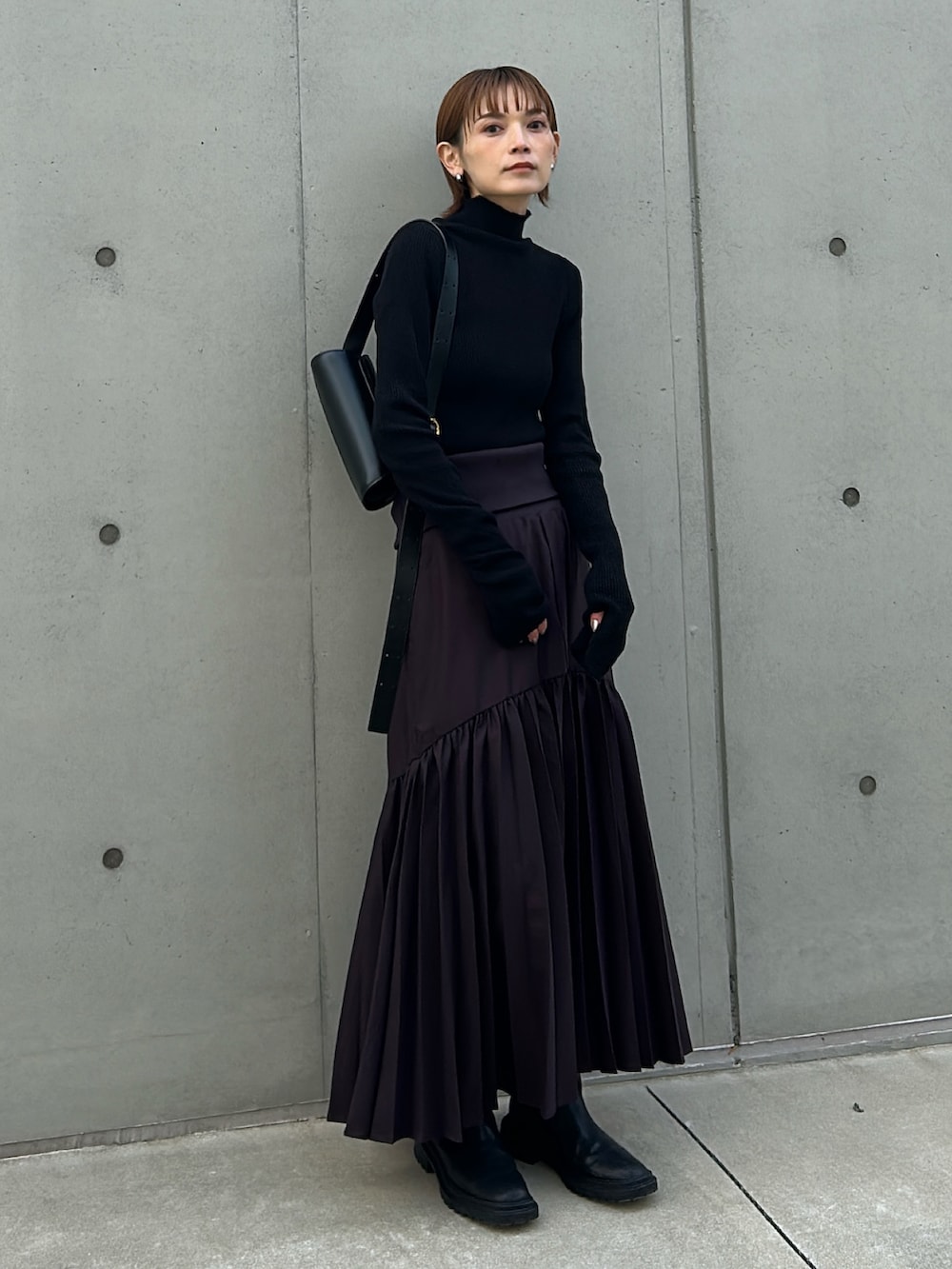 ブラック系のニット/セーターを着用したレディースの冬コーディネートの2枚目の写真