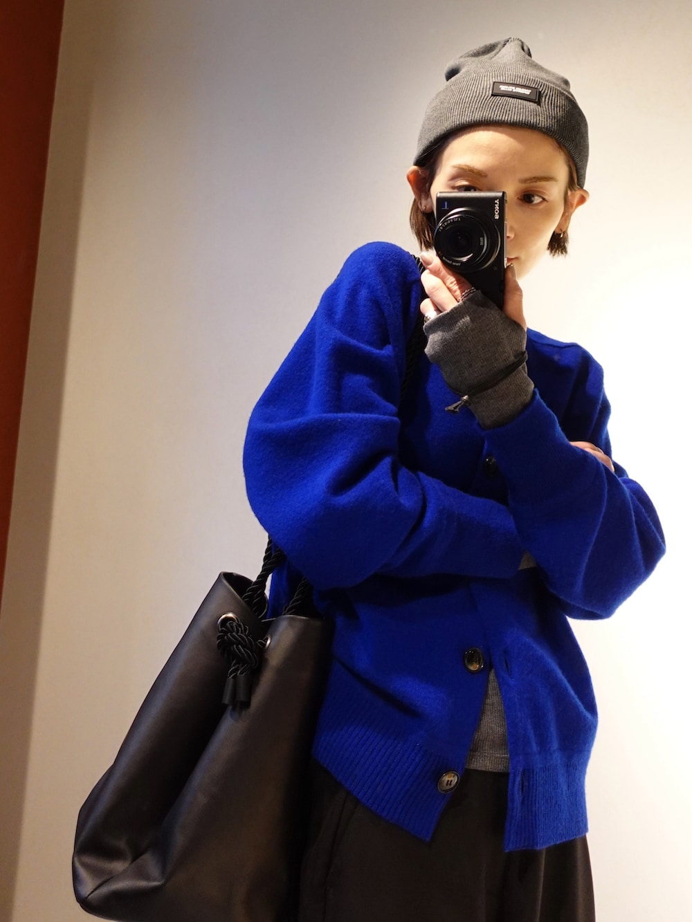 ブルー系のカーディガン/ボレロ、ブラック系のハンドバッグ、ブラック系のその他パンツを着用したレディースの冬コーディネートの2枚目の写真