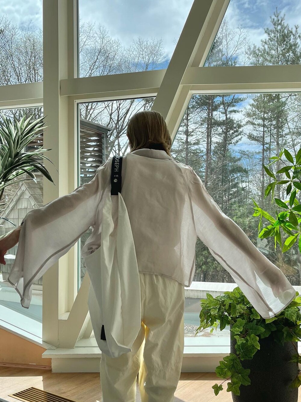 ホワイト系のその他パンツ、グレー系のシャツ/ブラウス、ホワイト系のエコバッグ/サブバッグを着用したレディースの春コーディネートの5枚目の写真