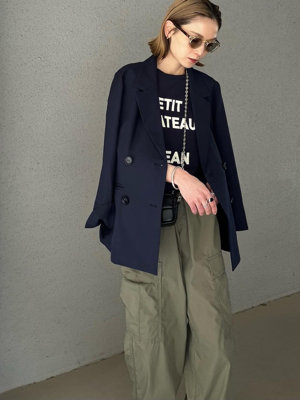 ブルー系のTシャツ/カットソー、ブラック系のショルダーバッグ、グリーン系のカーゴパンツを着用したレディースの春コーディネートの4枚目の写真