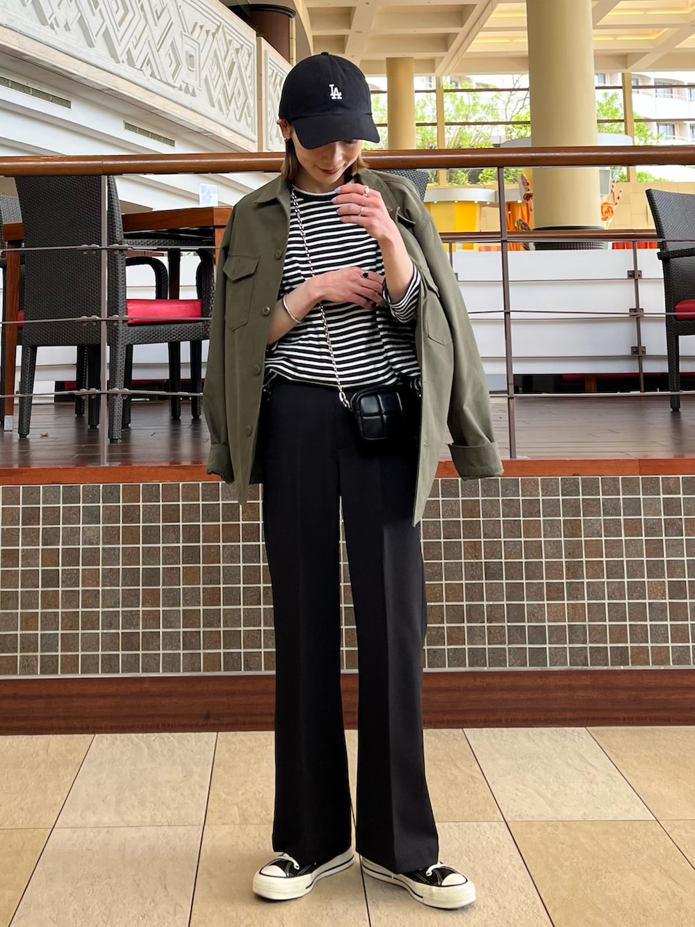 グリーン系のジャケット/アウター、ブラック系のトップス、ブラック系のスラックスを着用したレディースの春コーディネートの2枚目の写真