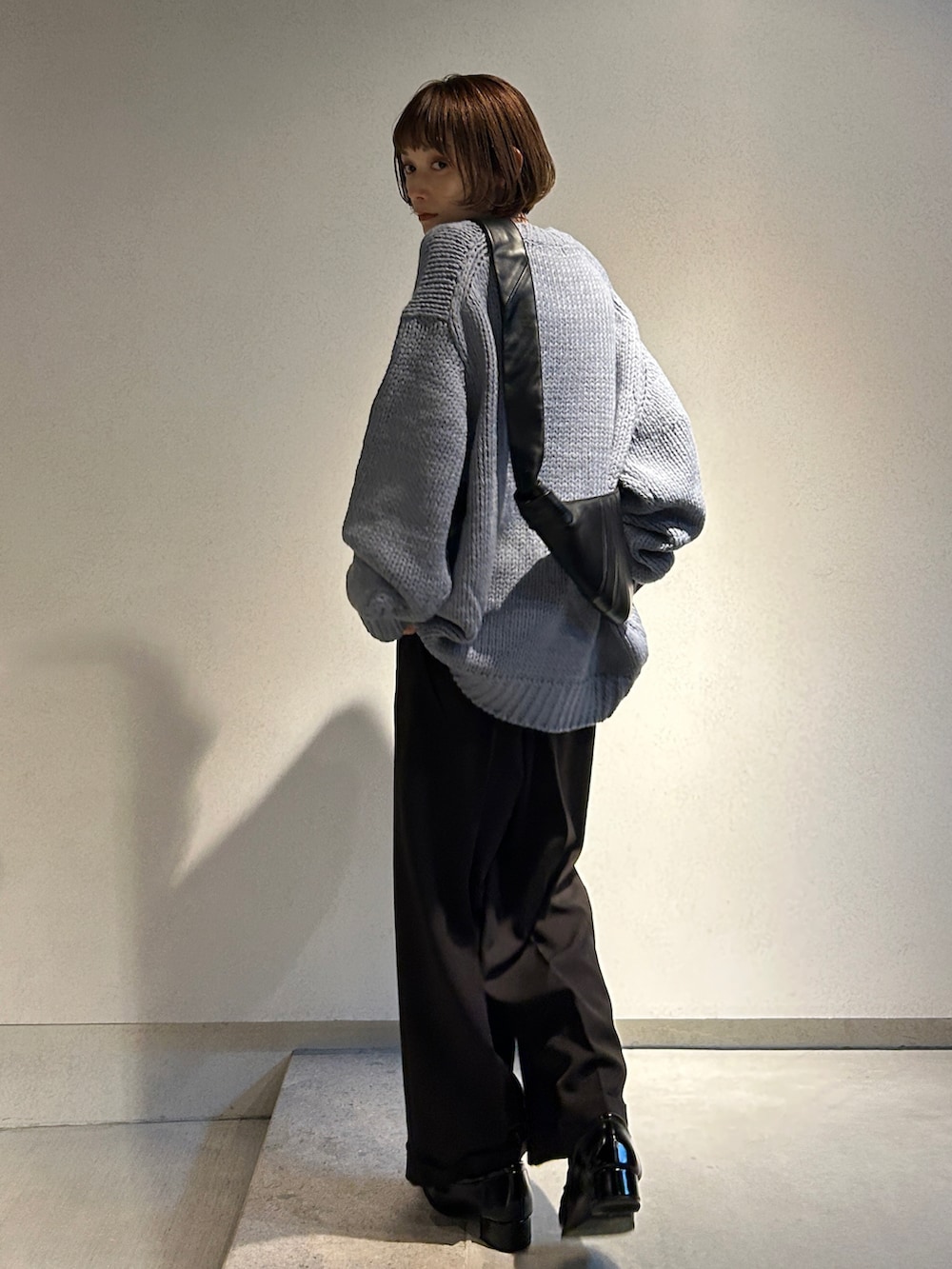 ブラウン系のスラックスを着用したレディースの冬コーディネートの2枚目の写真