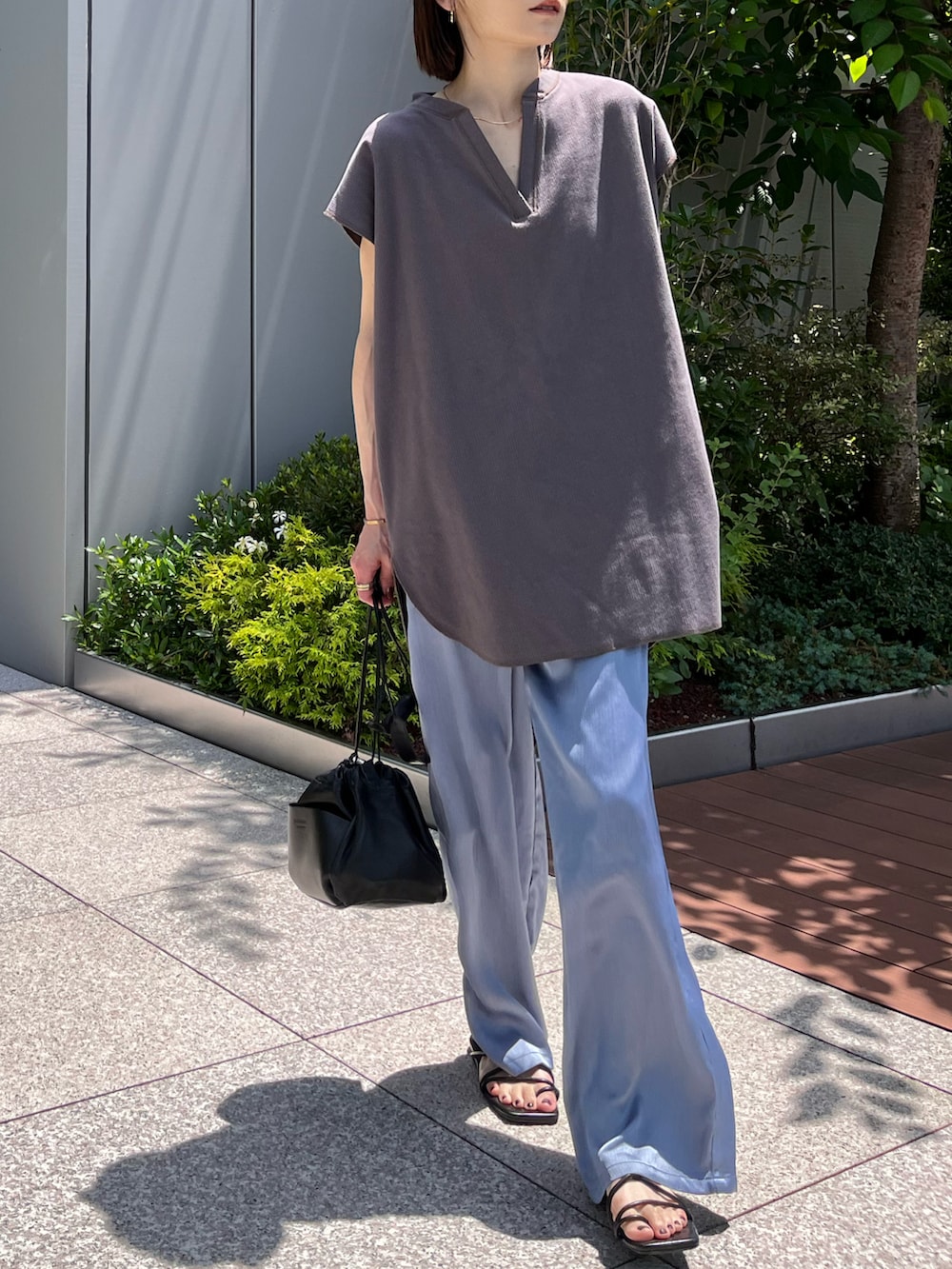 ブルー系のその他パンツ、グレー系のTシャツ/カットソー、ホワイト系のショルダーバッグを着用したレディースの夏コーディネートの4枚目の写真