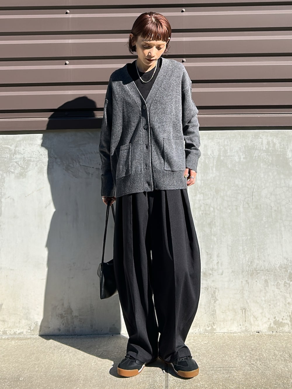 グレー系のカーディガン/ボレロ、グレー系のパンツを着用したレディースの秋コーディネートの2枚目の写真