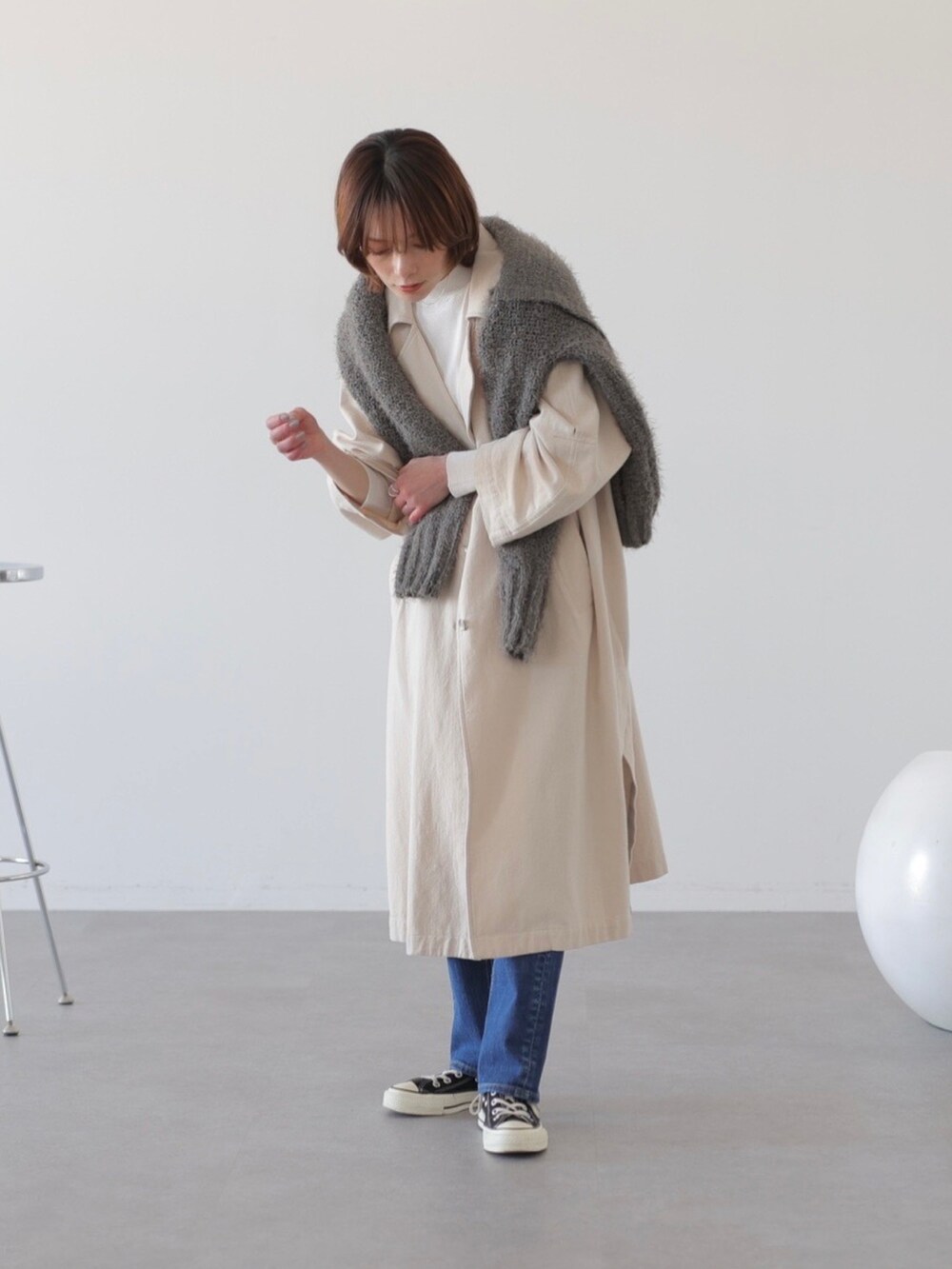 ブルー系のデニムパンツ、ベージュ系のチェスターコート、グレー系のニット/セーターを着用したレディースの冬コーディネートの3枚目の写真