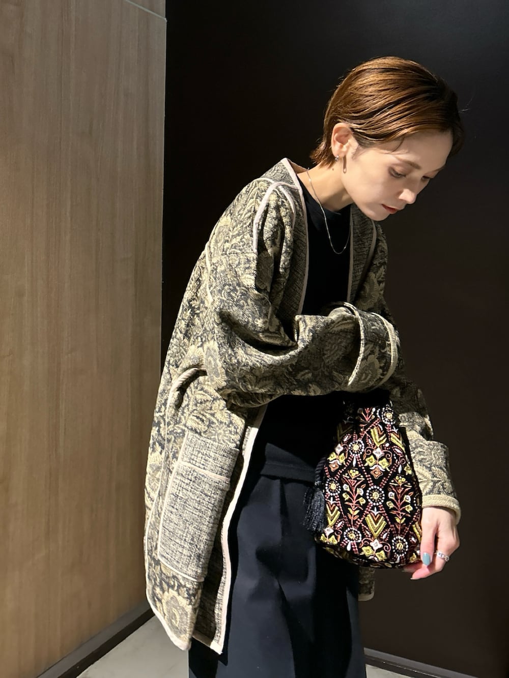 ブラック系のハンドバッグ、ブラック系のスニーカーを着用したレディースの秋コーディネートの4枚目の写真