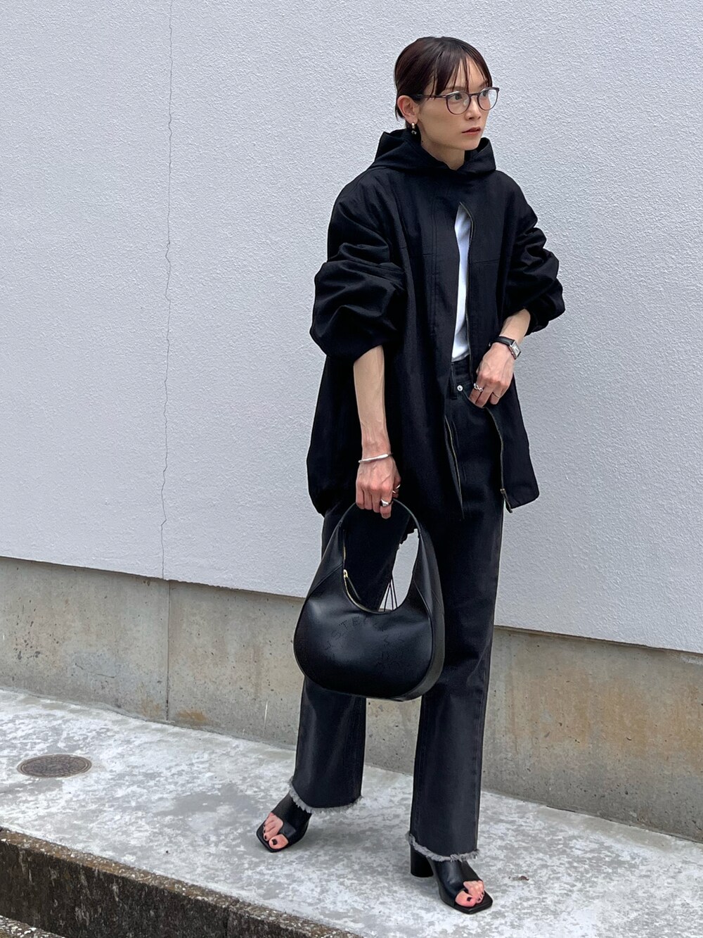 ブラック系のデニムパンツ、ブラック系のブルゾン、ブラック系のショルダーバッグを着用したレディースの夏コーディネートの2枚目の写真