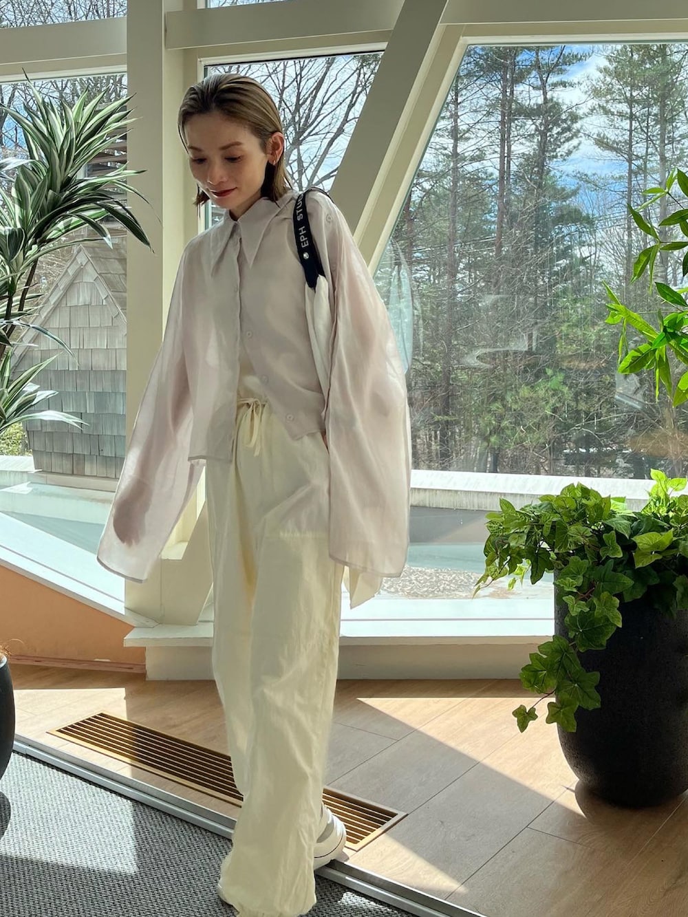 ホワイト系のその他パンツ、グレー系のシャツ/ブラウス、ホワイト系のエコバッグ/サブバッグを着用したレディースの春コーディネートの2枚目の写真