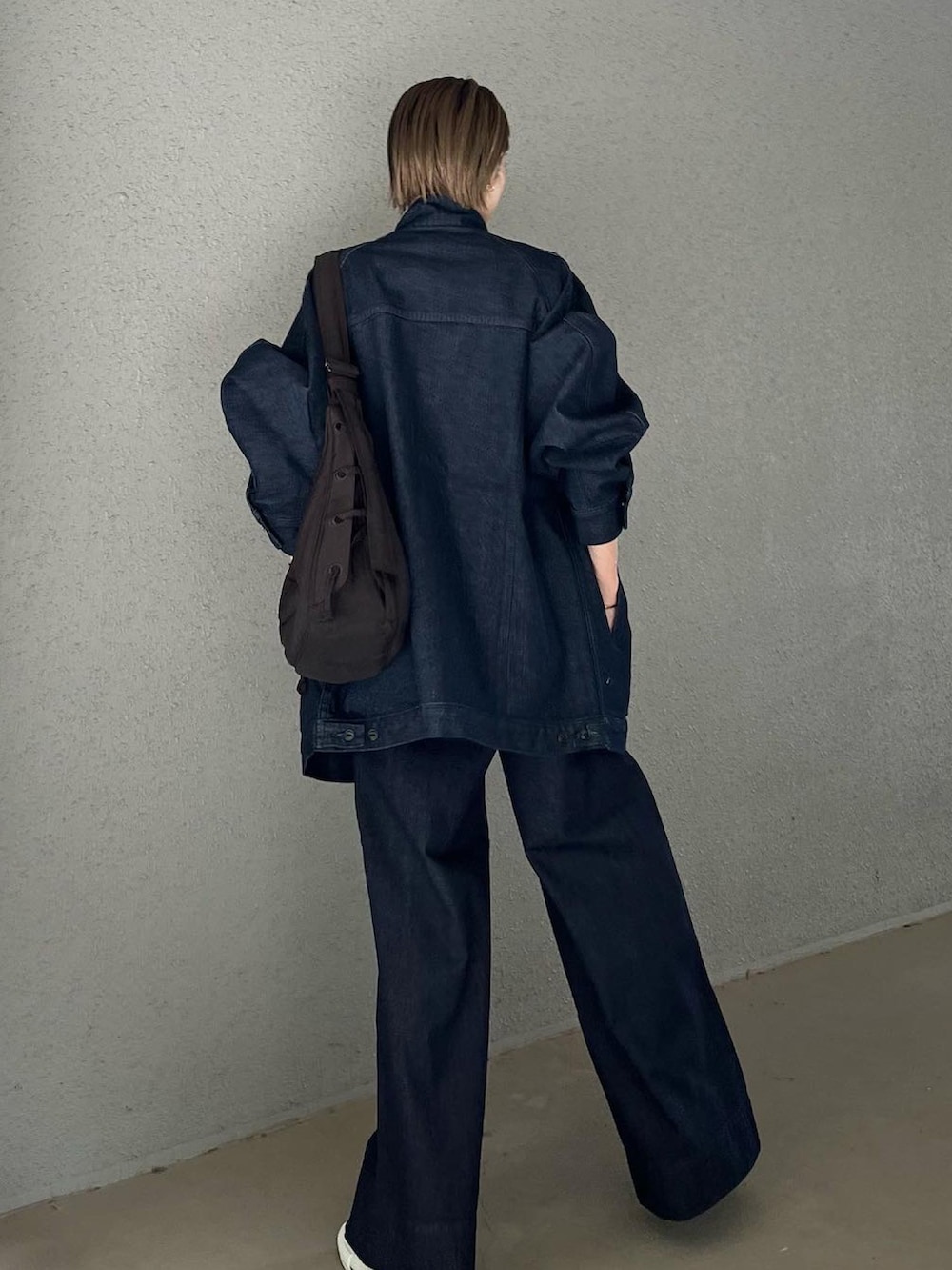 ブルー系のデニムジャケット、ブルー系のデニムパンツ、ブラウン系のショルダーバッグを着用したレディースの夏コーディネートの3枚目の写真