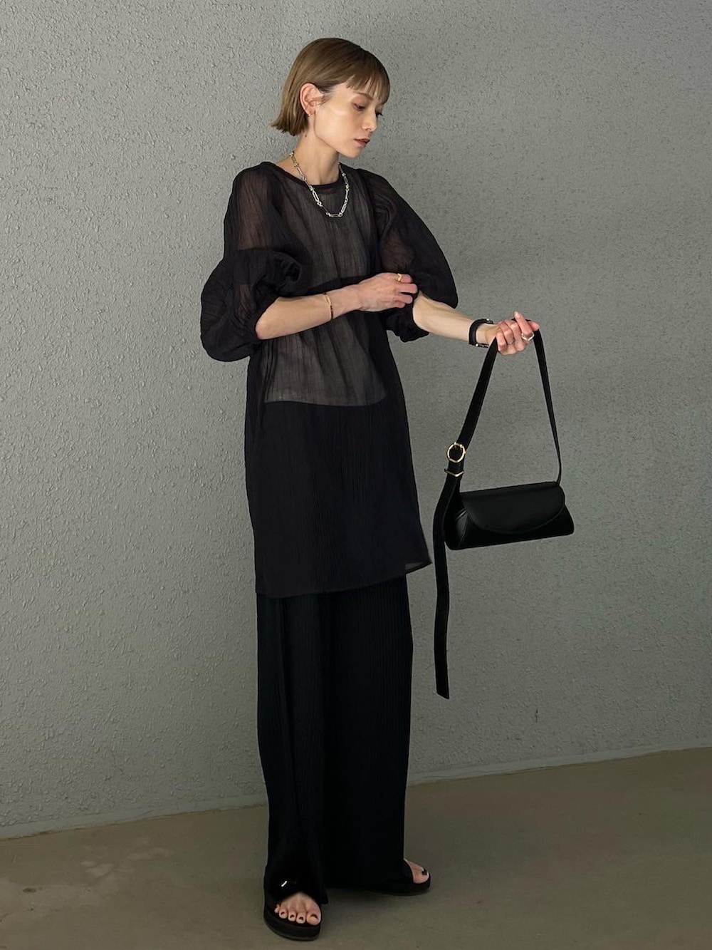 ブラック系のパンツ、ブラック系のシャツ/ブラウス、ブラック系のショルダーバッグを着用したレディースの夏コーディネートの2枚目の写真