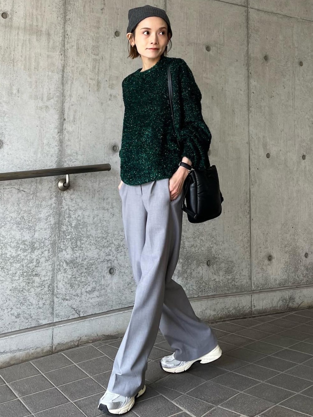 グリーン系のニット/セーター、グレー系のパンツ、シルバー系のスニーカーを着用したレディースの秋コーディネートの2枚目の写真