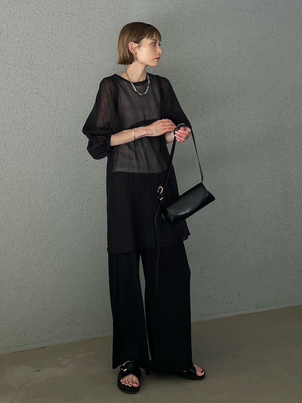 ブラック系のパンツ、ブラック系のシャツ/ブラウス、ブラック系のショルダーバッグを着用したレディースの夏コーディネートの4枚目の写真