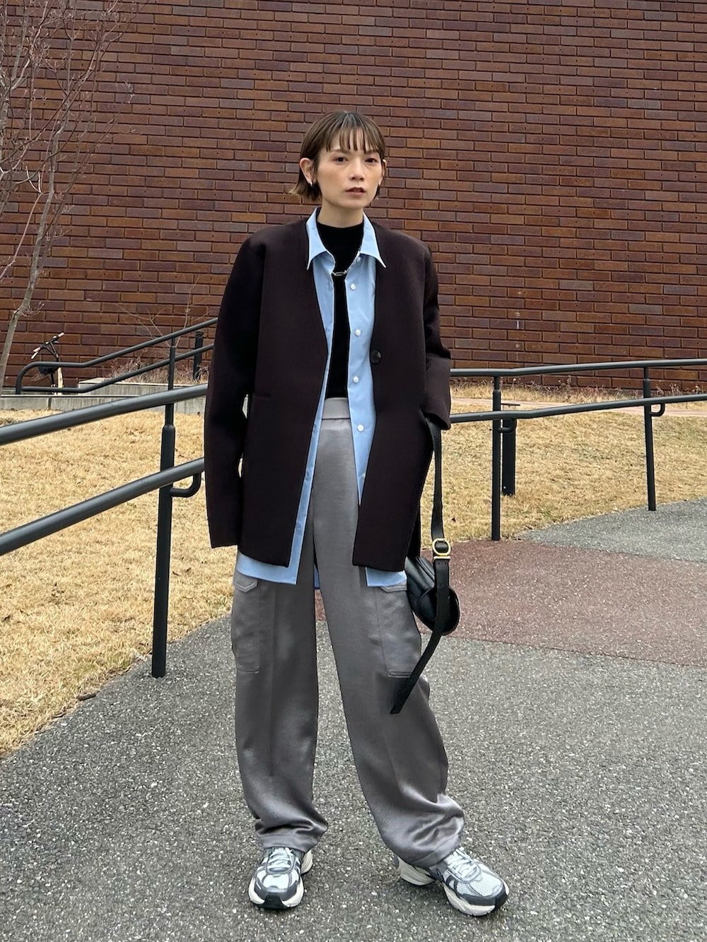 ブラウン系のその他アウター、ブラック系のショルダーバッグ、グレー系のスニーカーを着用したレディースの冬コーディネートの5枚目の写真