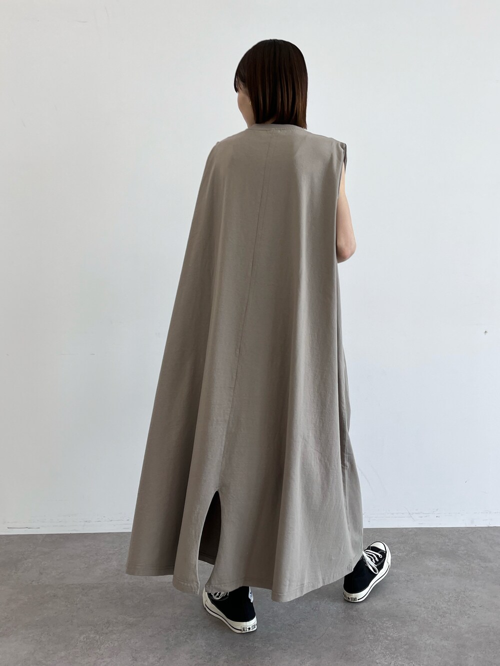 ベージュ系のワンピース、ブラック系のスニーカー、ブラック系のショルダーバッグを着用したレディースの夏コーディネートの2枚目の写真