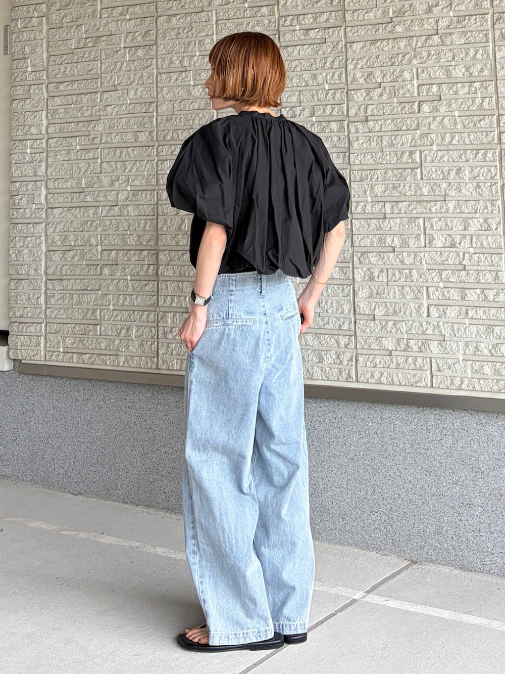 ブルー系のデニムパンツ、ブラック系のシューズを着用したレディースの夏コーディネートの2枚目の写真
