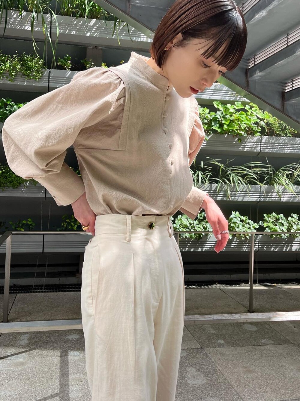 ホワイト系のその他パンツ、ベージュ系のシャツ/ブラウス、ブラウン系のパンプスを着用したレディースの春コーディネートの5枚目の写真