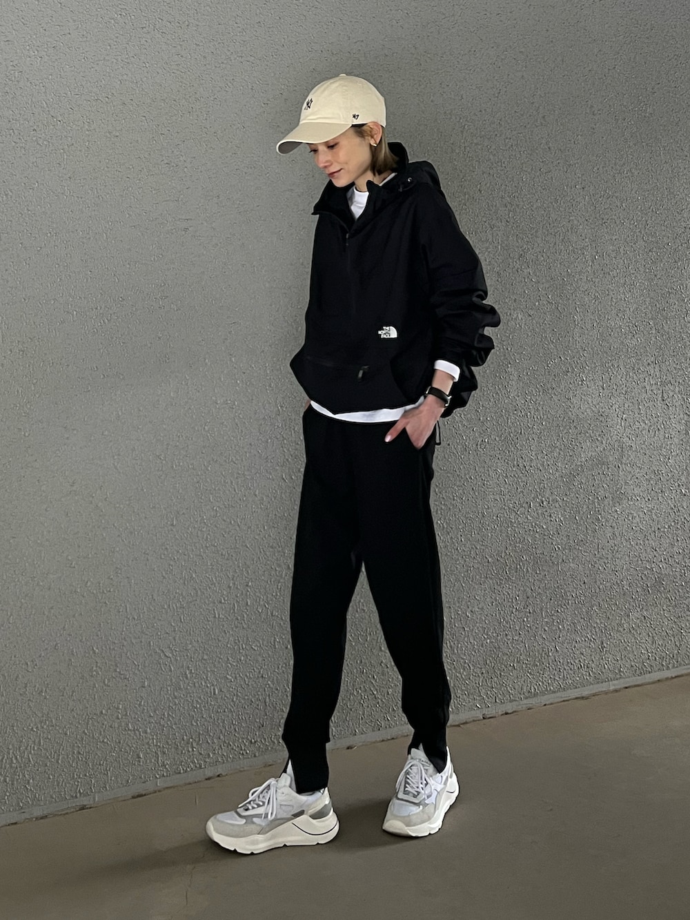 ブラック系のその他パンツ、ブラック系のマウンテンパーカー、ホワイト系のスニーカーを着用したレディースの春コーディネートの3枚目の写真