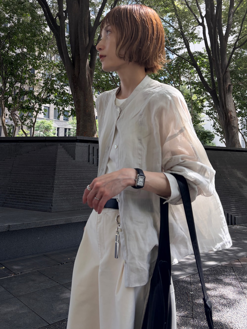 ブラック系のサンダル、ベージュ系のシャツ/ブラウス、ホワイト系のパンツを着用したレディースの夏コーディネートの5枚目の写真