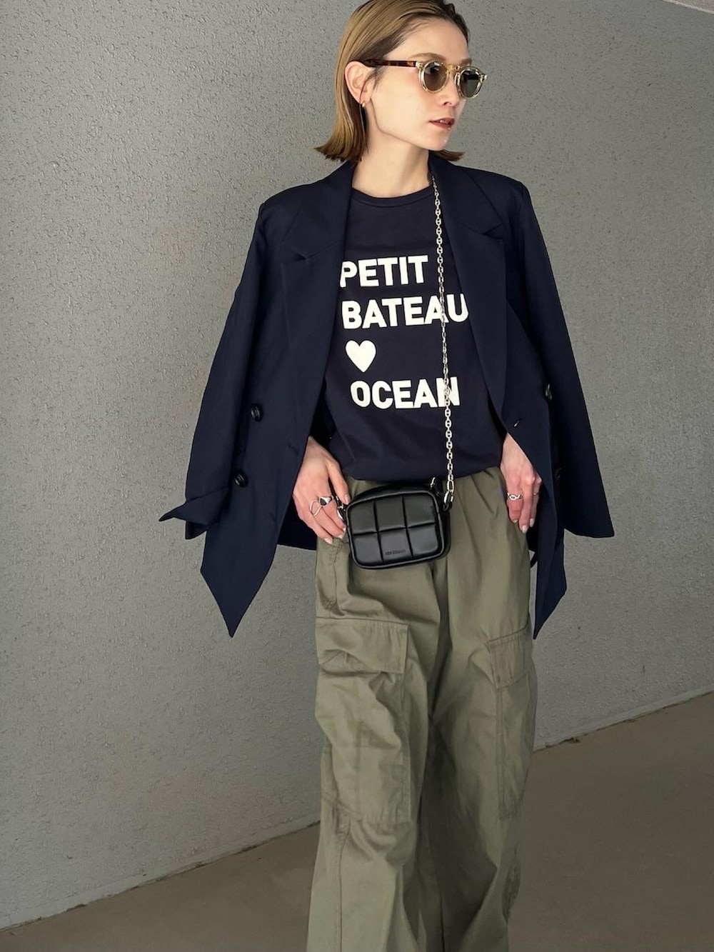 ブルー系のTシャツ/カットソー、ブラック系のショルダーバッグ、グリーン系のカーゴパンツを着用したレディースの春コーディネートの3枚目の写真