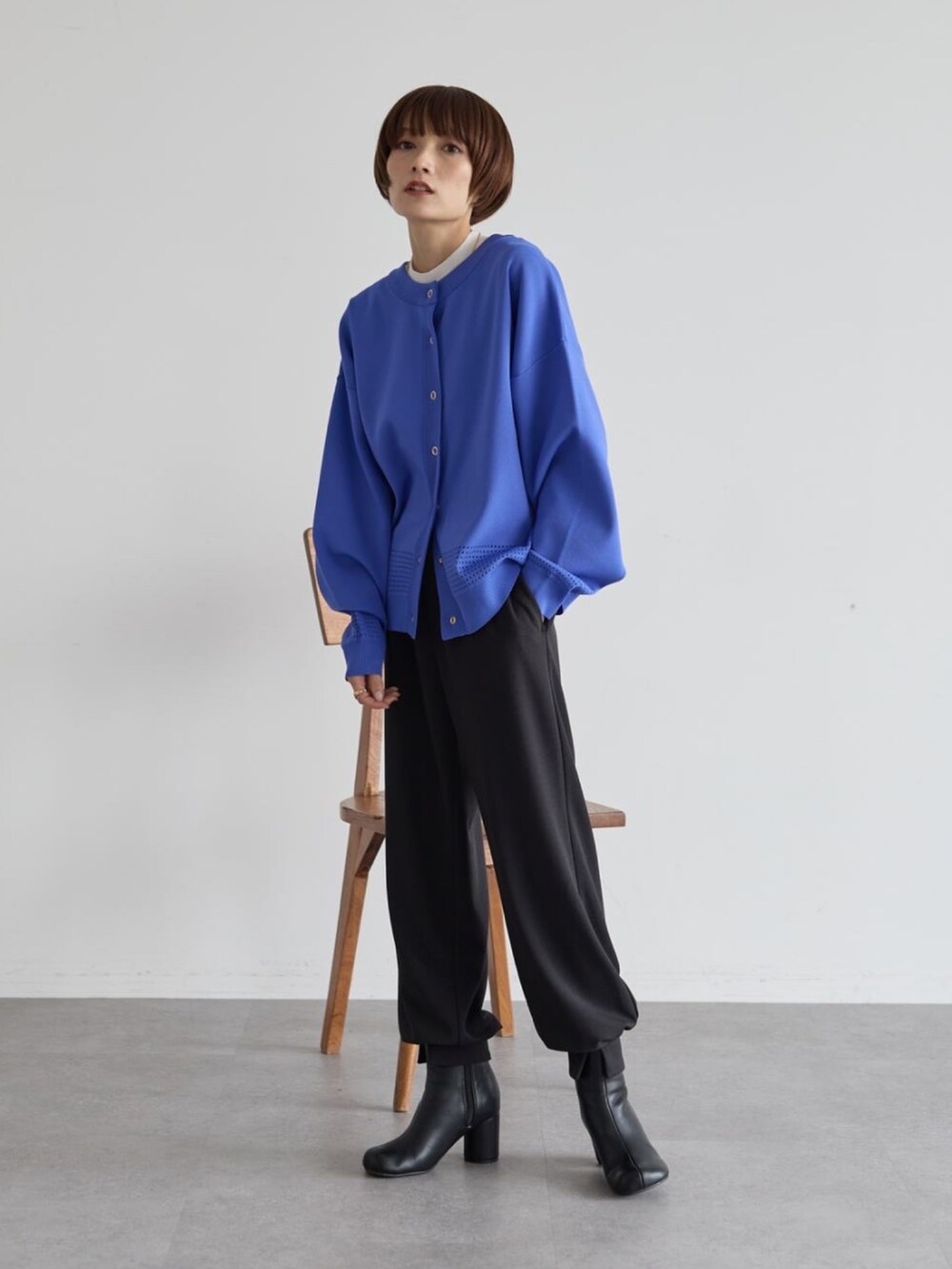 ブラック系のその他パンツ、ブラック系のブーツ、ブルー系のニット/セーターを着用したレディースの秋コーディネートの2枚目の写真