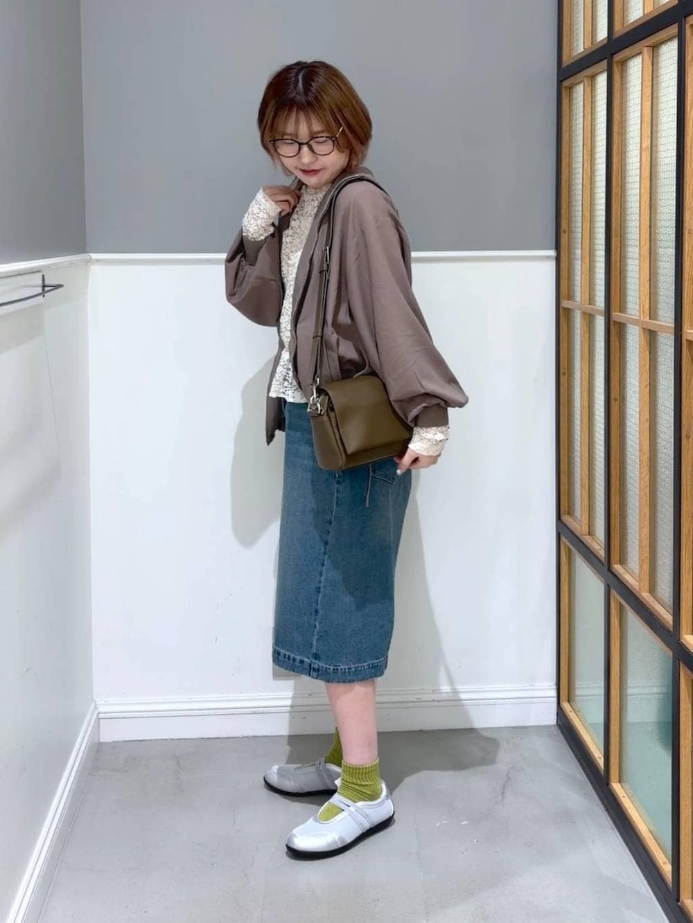 ブラウン系のショルダーバッグ、ブラウン系のブルゾン、シルバー系のパンプスを着用したレディースの春コーディネートの2枚目の写真