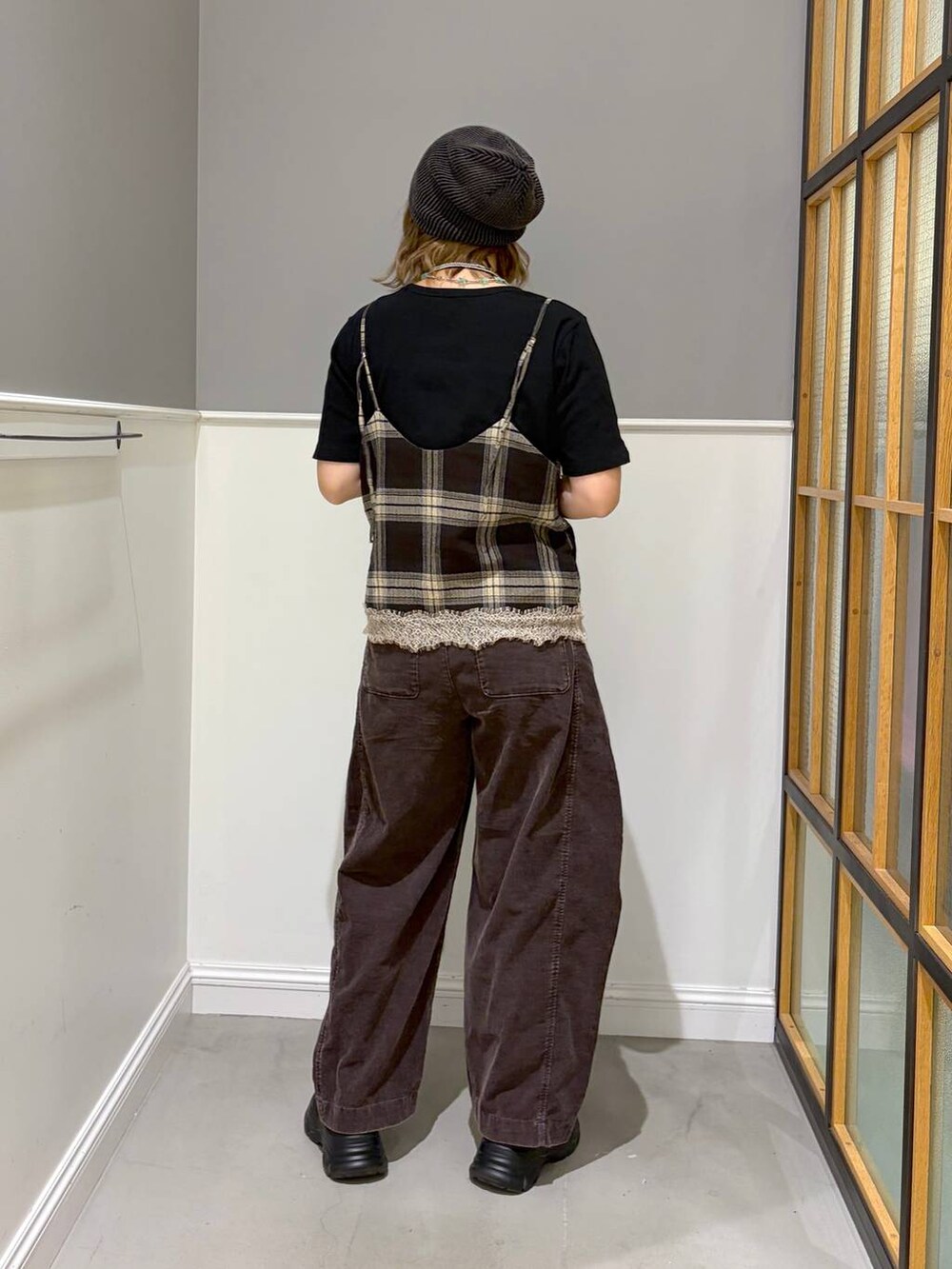 ブラウン系のその他パンツ、ブラウン系のキャミソール、ブラック系のスニーカーを着用したレディースの秋コーディネートの3枚目の写真