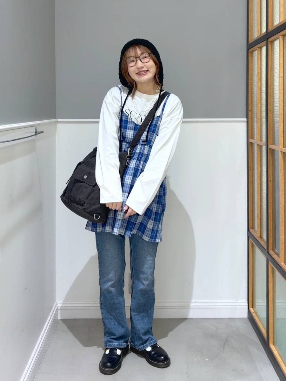 ブラック系のショルダーバッグ、ホワイト系のTシャツ/カットソー、ブルー系のキャミソールを着用したレディースの春コーディネートの4枚目の写真