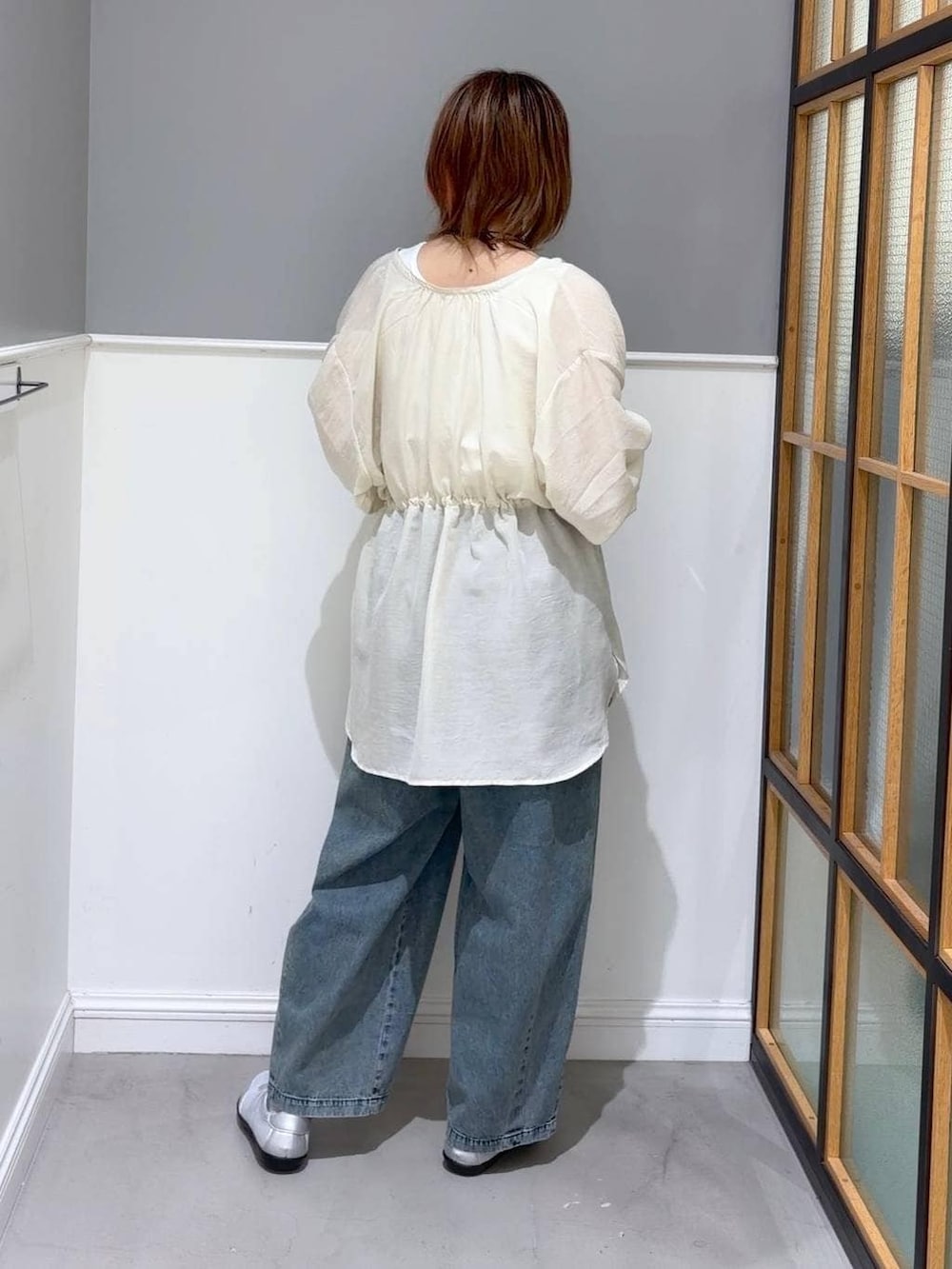 シルバー系のパンプス、ホワイト系のシャツ/ブラウス、ブルー系のデニムパンツを着用したレディースの春コーディネートの3枚目の写真