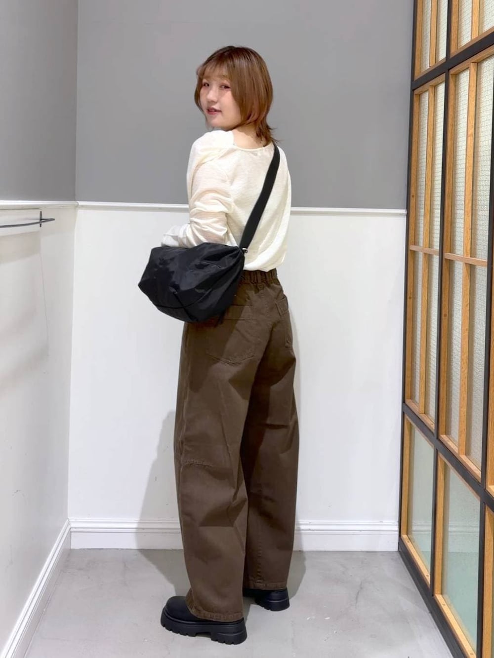 グリーン系のその他パンツ、ブラック系のその他シューズ、ブラック系のショルダーバッグを着用したレディースの春コーディネートの2枚目の写真
