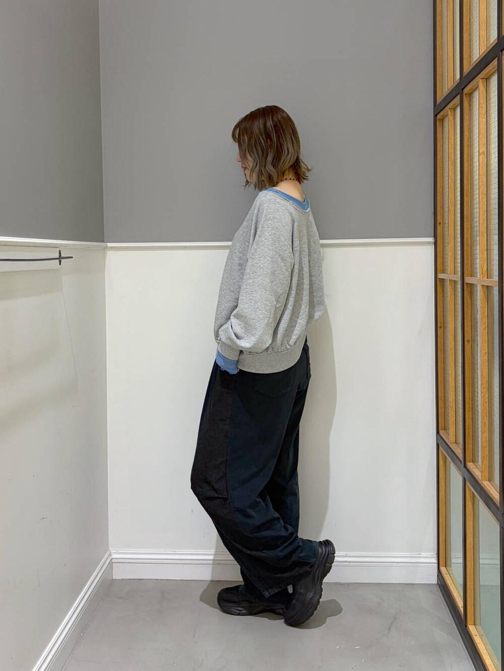 ブルー系のデニムパンツ、グレー系のその他トップス、ブラック系のスニーカーを着用したレディースの秋コーディネートの2枚目の写真