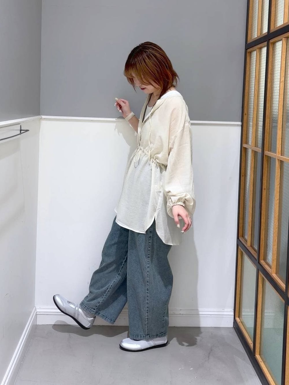 シルバー系のパンプス、ホワイト系のシャツ/ブラウス、ブルー系のデニムパンツを着用したレディースの春コーディネートの2枚目の写真