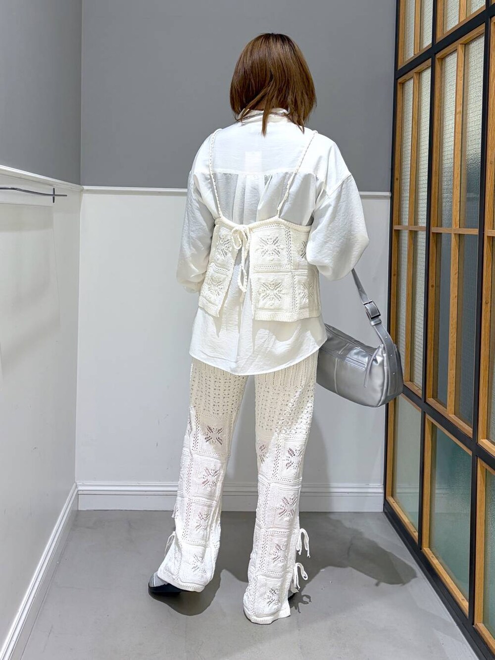 シルバー系のショルダーバッグ、ホワイト系のシャツ/ブラウス、シルバー系のパンプスを着用したレディースの冬コーディネートの3枚目の写真