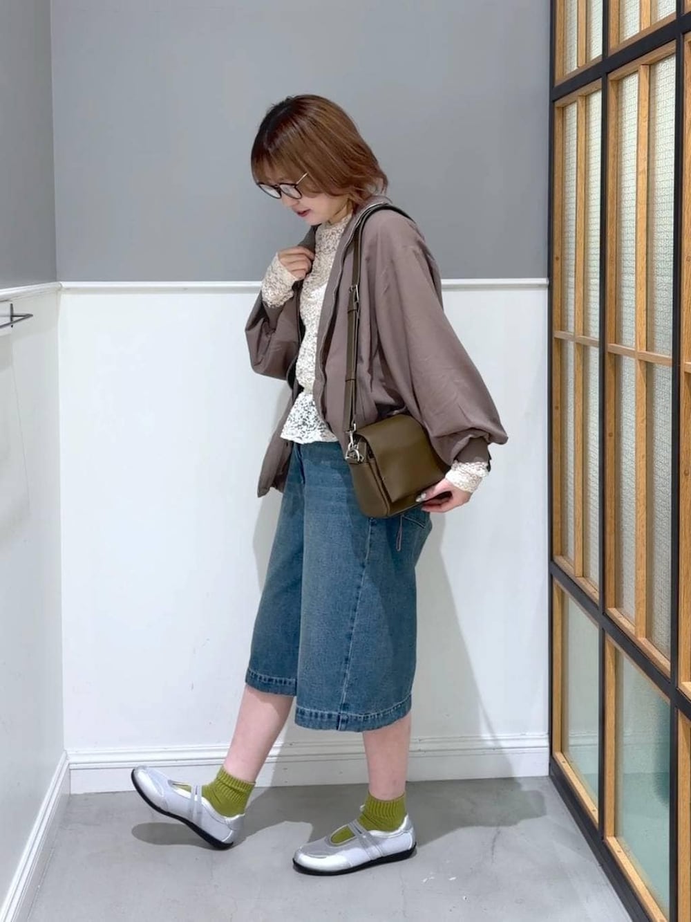 ブラウン系のショルダーバッグ、ブラウン系のブルゾン、シルバー系のパンプスを着用したレディースの春コーディネートの3枚目の写真