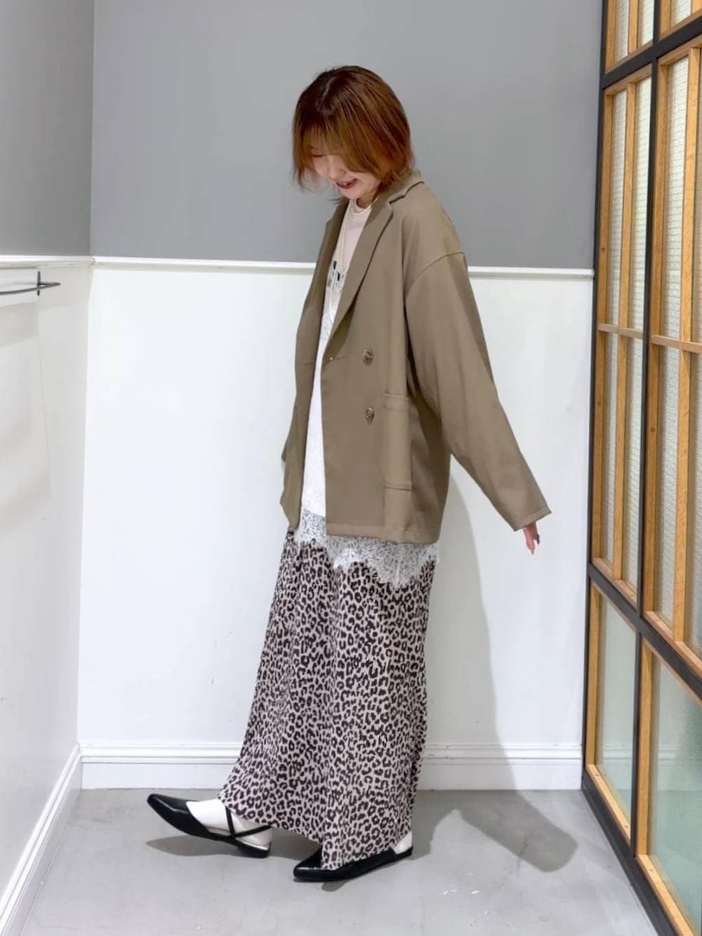 ブラック系のパンプス、ホワイト系のキャミソール、その他のスカートを着用したレディースの春コーディネートの2枚目の写真