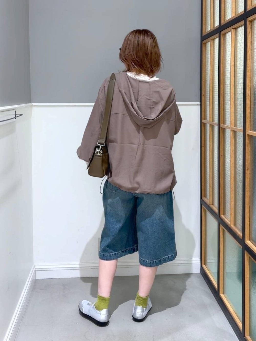 ブラウン系のショルダーバッグ、ブラウン系のブルゾン、シルバー系のパンプスを着用したレディースの春コーディネートの4枚目の写真