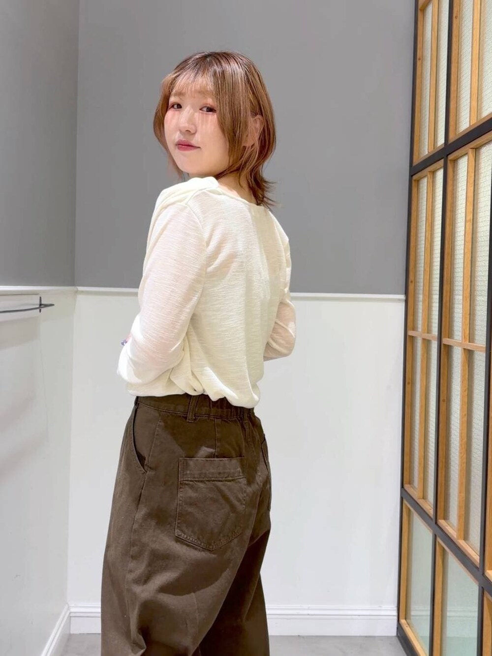グリーン系のその他パンツ、ブラック系のその他シューズ、ブラック系のショルダーバッグを着用したレディースの春コーディネートの3枚目の写真